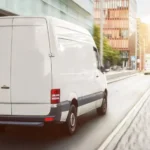 Weißer Kleintransporter auf einer städtischen Straße - Effizienter Transport mit einem VW T6 kaufen